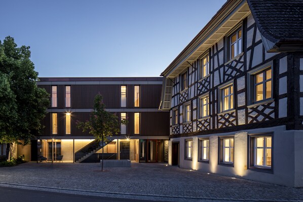 A modern building with a traditional half-timbered facade, a courtyard with seating, and a staircase leading to the entrance. - Sternen Bohlingen Aparthotel (Singen)