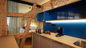 Una cocina moderna con vigas de madera, una pared azul de acento y un lavamanos de acero inoxidable.