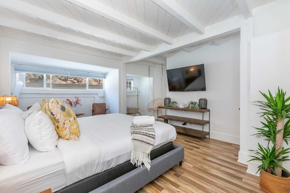 A modern bedroom with a bed, a TV, a window, and a plant. - Casa del Mar by Oraklus (Malibu)