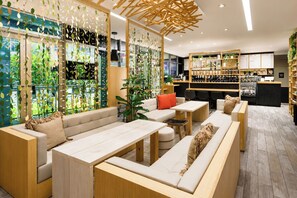A modern lounge area with sofas, tables, and a bar area with shelves of bottles. - 1BR Gorgeous Parcial view Beach, Resort 4 Pax (Hollywood)
