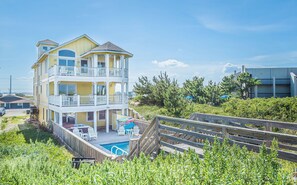 A multi-story building with balconies, a swimming pool, and outdoor seating. - Savannah - Nags Head MP 16, Oceanfront, Direct Beach Access, Pool, Hot Tub, Pool Table (Nags Head)