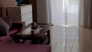 A room with a bed, a desk, a chair, a globe on the desk, and a window with curtains. - Immaculate 2-bed Apartment (Paiania)