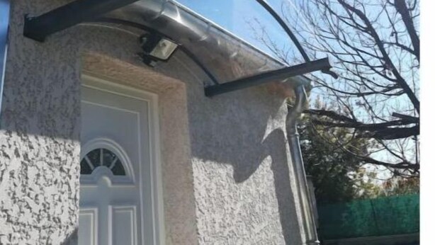 A building with a stone facade, a white door, and a metal gutter system. - CHARMING 2 ROOM APARTMENT WITH ALL COMFORTS + AIR CONDITIONING (Tornac)