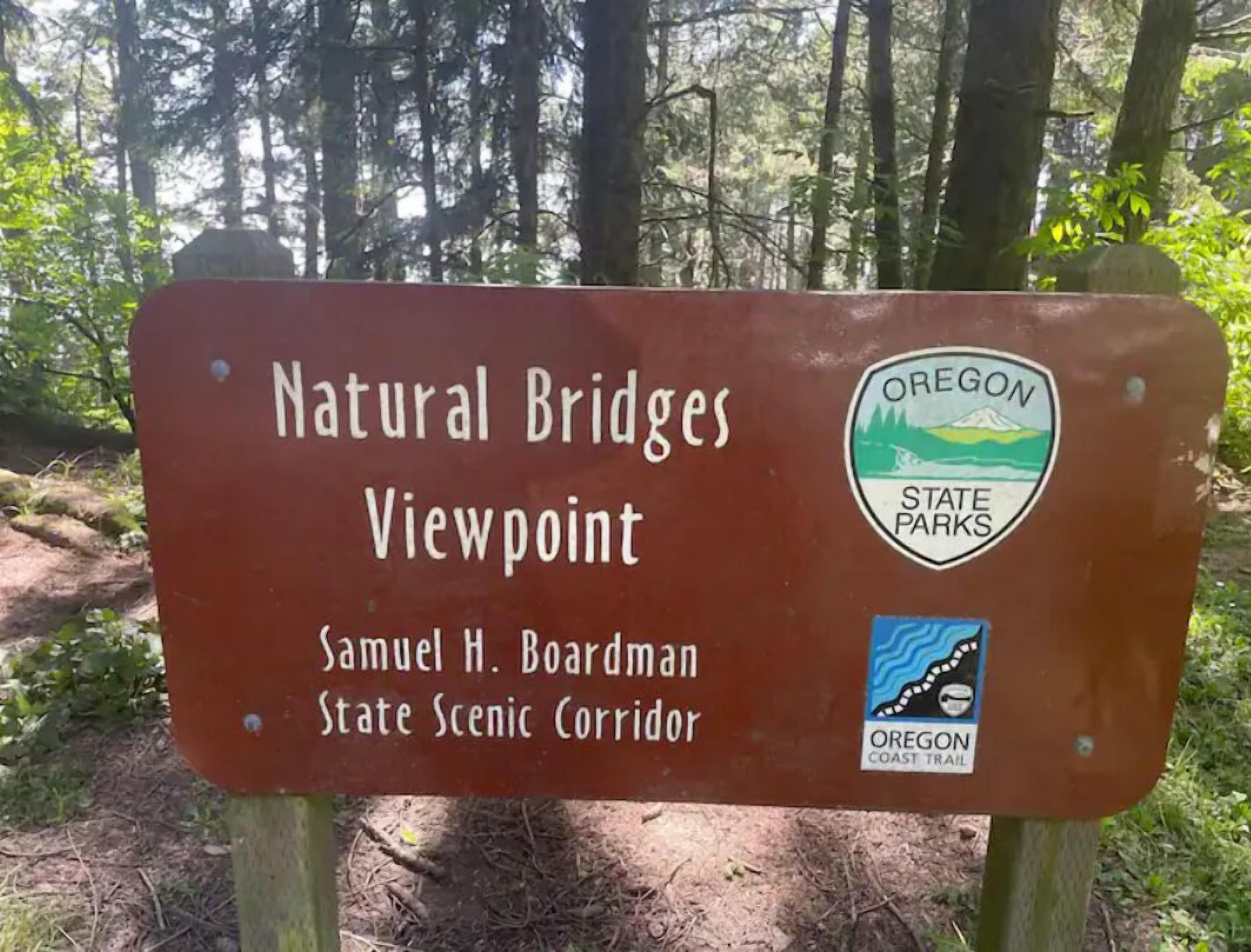 A sign for Natural Bridges Viewpoint in Oregon State Parks, mentioning Samuel H. Boardman State Scenic Corridor.