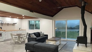 A modern living room with a sofa, coffee table, and a fireplace. - Indoor heated pool ocean views. Fishing short walk away. Pet Friendly!  (Smith River)