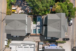 Vista aérea de uma propriedade com dois edifícios grandes, piscina e área de estacionamento.