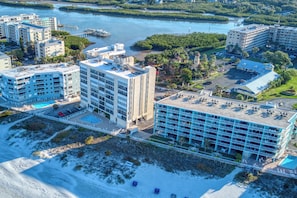 A coastal hotel with multiple buildings, a swimming pool, and a beach area.