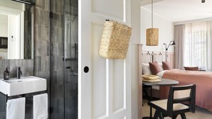 A modern bathroom with a glass shower, a white sink, and a door with a woven basket.