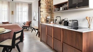 A modern kitchen with a brick accent wall, a built-in microwave, and a dining area with a round table and chairs.