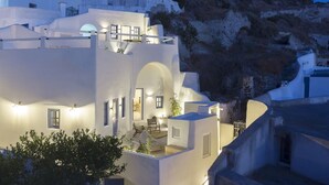 A white building with multiple balconies and a dining area. - Acave Santorini Suites (Santorini)