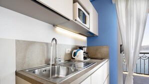 A modern kitchen with a stainless steel sink, a kettle, and a microwave. - Studio 2- lake view - Studio Apartment, Sleeps 2 (Oggebbio)