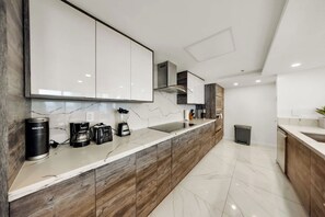 A modern kitchen with a marble countertop, wooden cabinets, and built-in appliances. - High-Floor Ocean View 2-Bedroom | Balcony (Miami)