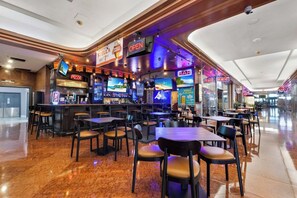 Ein Restaurant mit Barbereich, mehreren Fernsehern und verschiedenen Sitzmöglichkeiten.