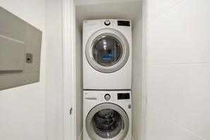Une buanderie équipée de deux machines à laver superposées.