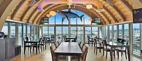 Un restaurante con techo abovedado, ventanas amplias y una decoración con forma de tiburón.