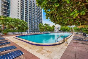 A rooftop swimming pool with lounge chairs and palm trees. - Spacious bay-view balcony stay near Art Miami (Miami)
