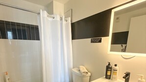 A modern bathroom with a shower, toilet, and sink. - Cozy 2BR Near Airport 4wef (Elizabeth)
