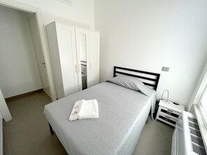 2 dormitorios, tabla de planchar con plancha, ropa de cama