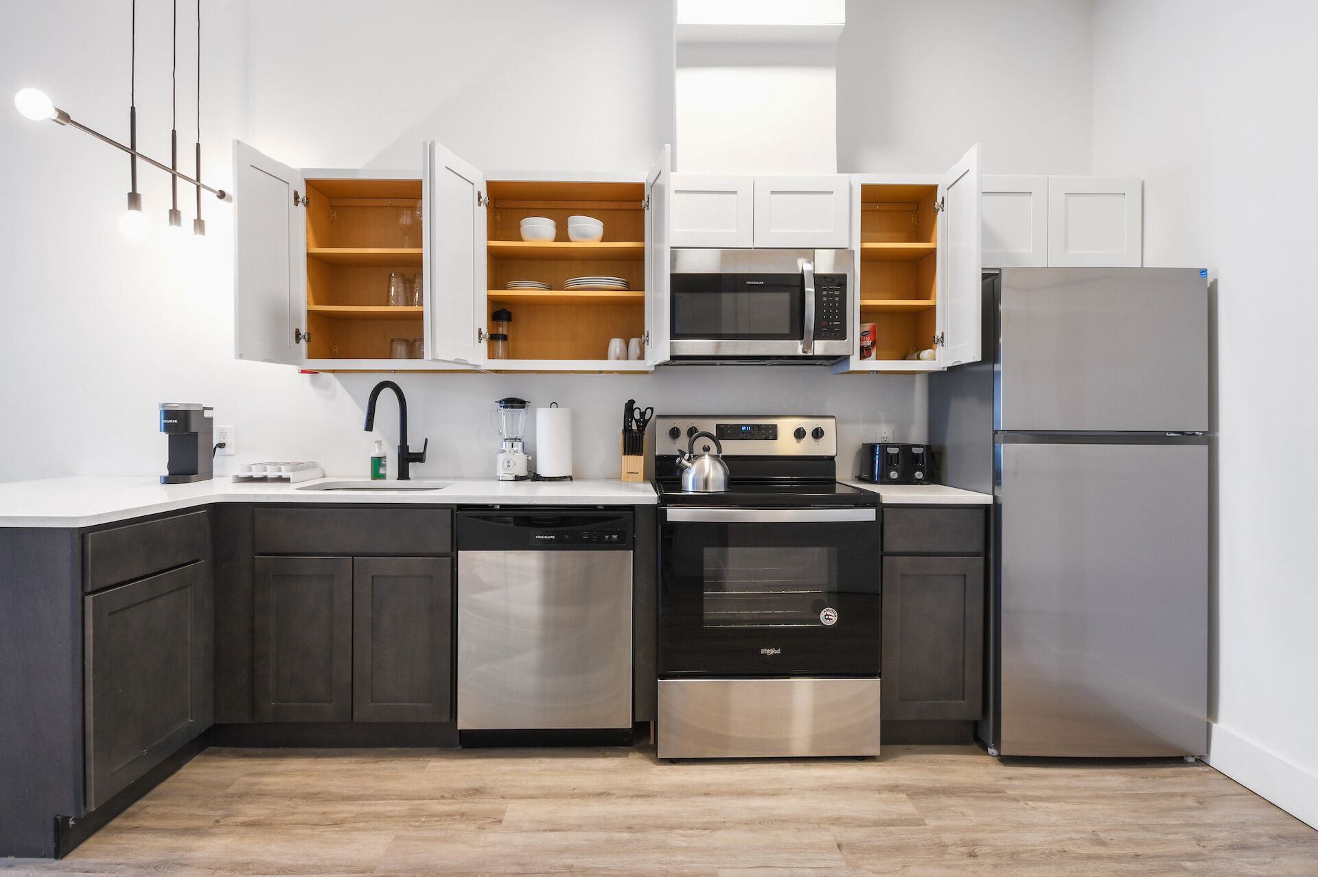 Eine moderne Küche mit Geschirrspüler, Herd, Backofen, Mikrowelle und Kühlschrank.
