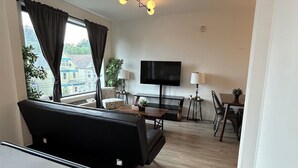 Une chambre d’hôtel équipée d’un lit, d’un bureau, d’une chaise, d’une télévision et d’une fenêtre avec des rideaux.