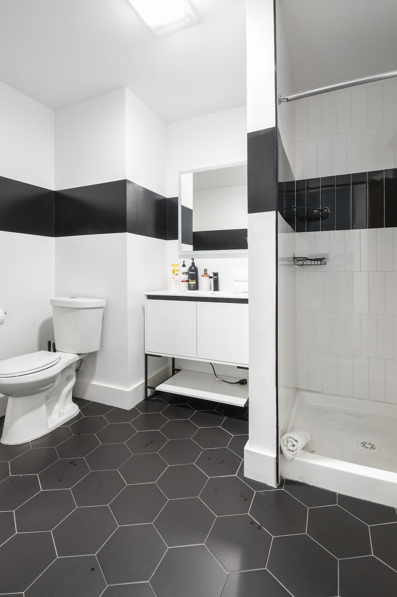 A modern bathroom with a toilet, sink, and shower.
