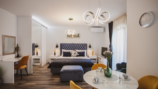 Een moderne hotelkamer met een groot bed, een bureau, een zithoek en een woongedeelte.