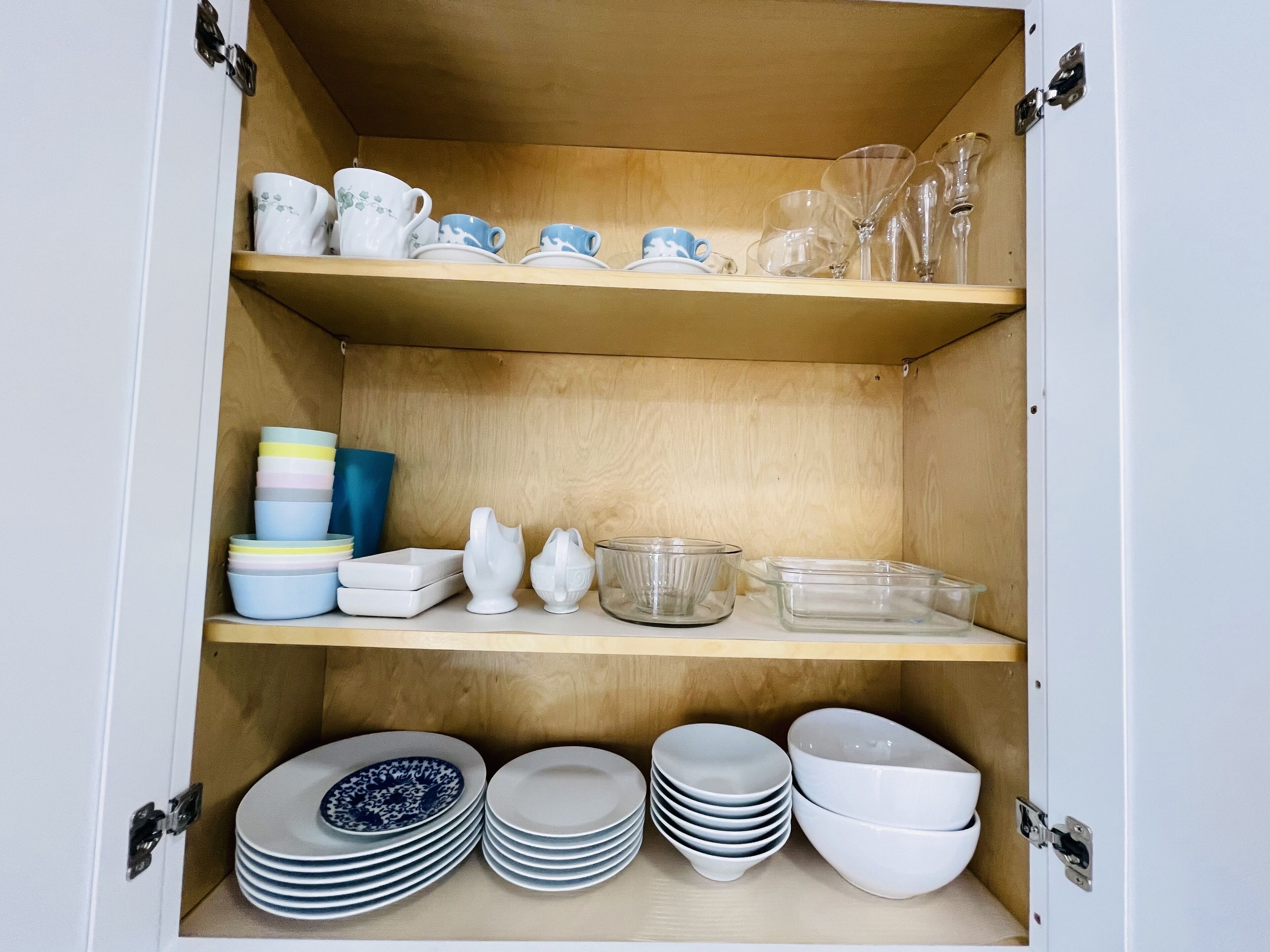 Un mobile contenitore con ripiani e diversi utensili da cucina.