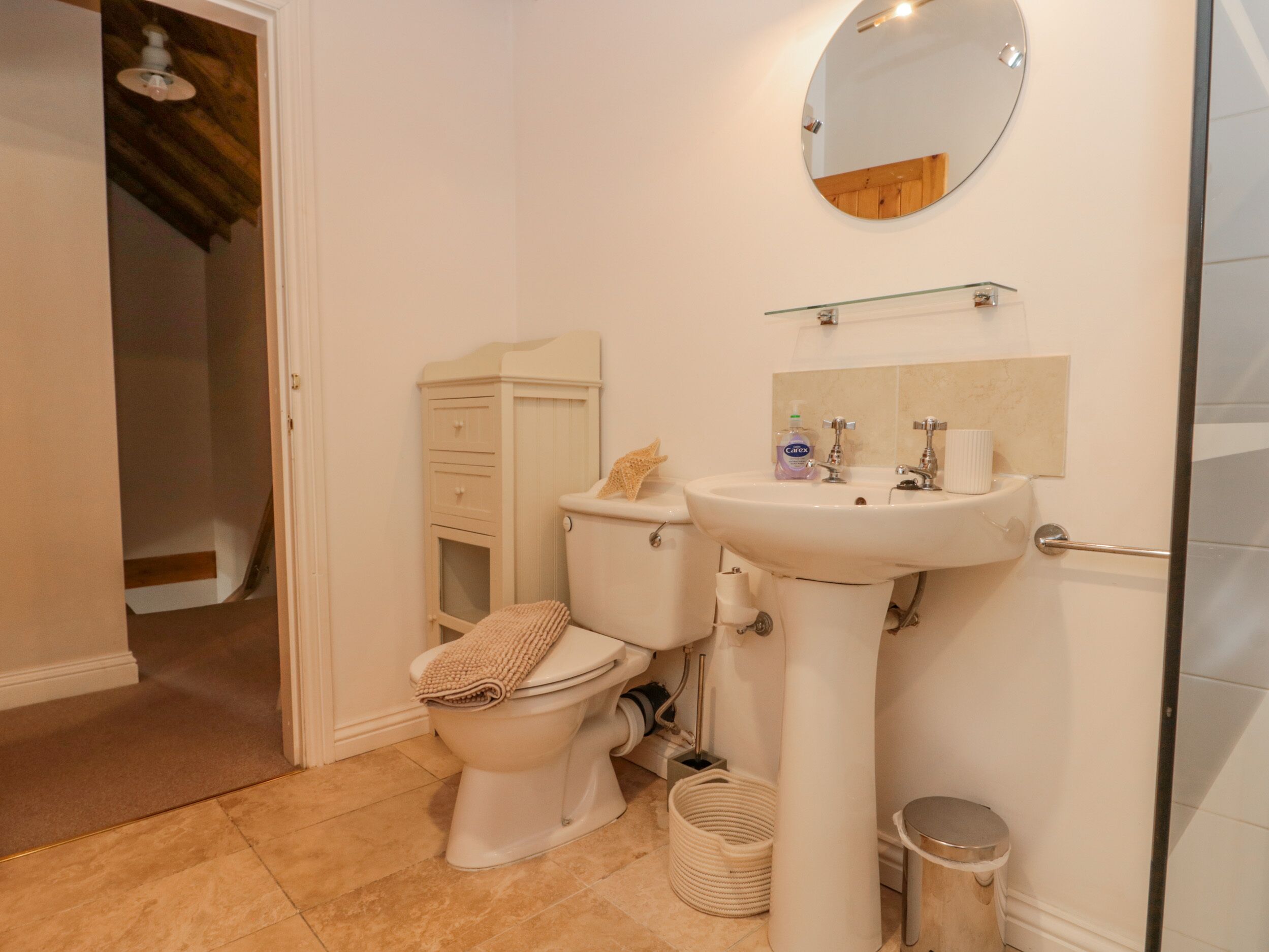 Un baño con inodoro, lavabo y espejo.