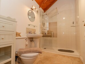 Une salle de bain avec des toilettes, un lavabo et une douche.