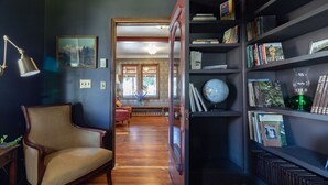 A room with a wooden floor, a bookshelf, a desk with a lamp, and a chair. - #2 Laughingwater Creek Trail Shared Bath- Adults only (Lewis County)