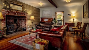 Un acogedor salón de hotel con chimenea, sofá de cuero y un letrero que dice "HOTEL PACKWOOD Bed & Breakfast".