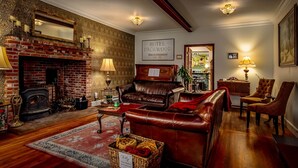 Un acogedor vestíbulo de hotel con chimenea, sofá de cuero y un cartel que dice 'HOTEL PACKWOOD'.