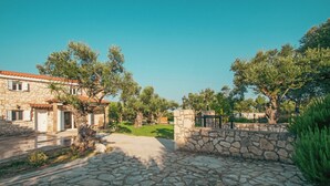 A stone house with a red-tiled roof, a stone pathway, and a stone wall with a gate. - Il Greco   (Zakynthos)