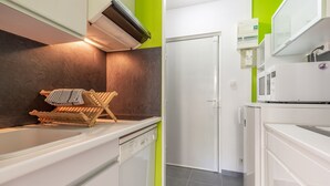 A compact kitchen with a dishwasher, a microwave, and a small refrigerator. - L'Ourson des Myrtilles (La Bresse)