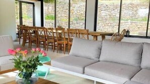 Un espace extérieur moderne aménagé avec un canapé, des fauteuils et une table.