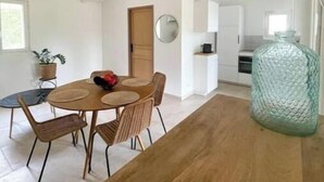 Eine moderne Küche mit weißen Schränken, einem Holzespeisetisch und einer Pendelleuchte.