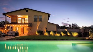 A two-story house with a swimming pool, outdoor furniture, and a well-lit patio area. - Heated Pool and Hot Tub -Casa Bonita An Irvie Home (Albuquerque)