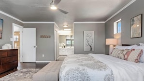 A bedroom with a large bed, a dresser, a ceiling fan, and artwork on the walls. - Heated Pool and Hot Tub -Casa Bonita An Irvie Home (Albuquerque)
