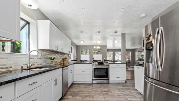 A modern kitchen with white cabinets, a stainless steel refrigerator, and a central island. - Heated Pool and Hot Tub -Casa Bonita An Irvie Home (Albuquerque)