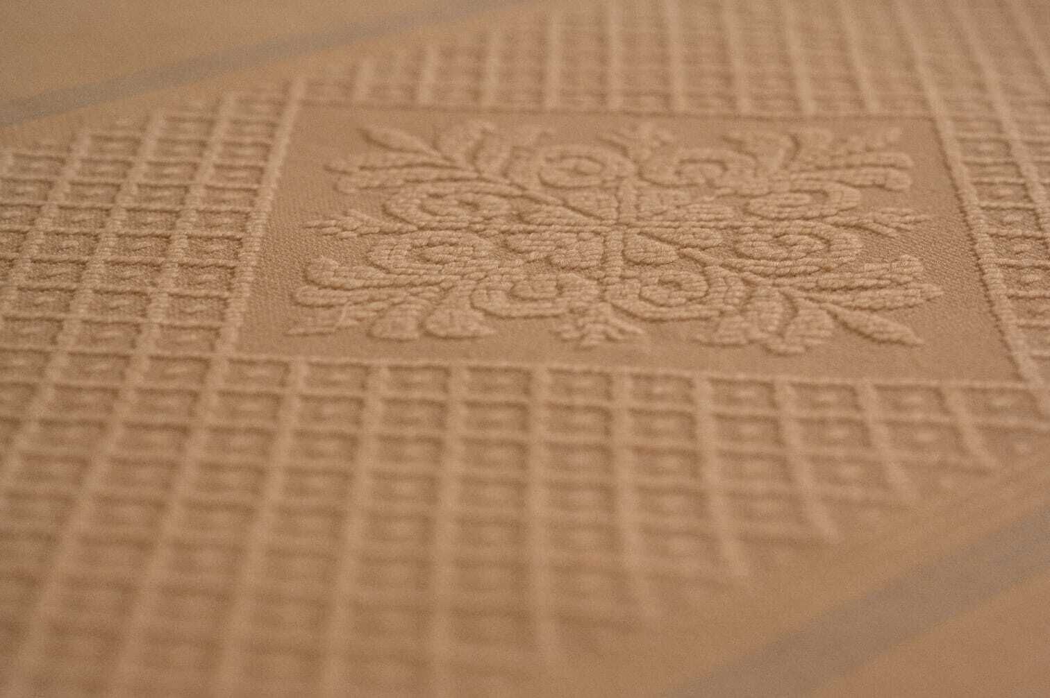 Un gros plan d’une moquette à motifs floraux et à la texture particulière.