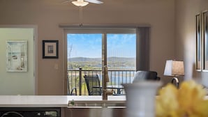 A dining area with a view of a balcony, a chair, a table, and a lamp. - Majestic View Getaway w/ Beautiful Lake Views! (Branson)