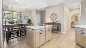 A spacious kitchen with wooden flooring, a central island, and a dining area with benches. - Majestic View Getaway w/ Beautiful Lake Views! (Branson)