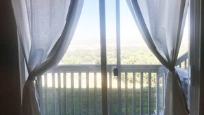 Ein Balkon mit Blick auf eine grüne Landschaft.