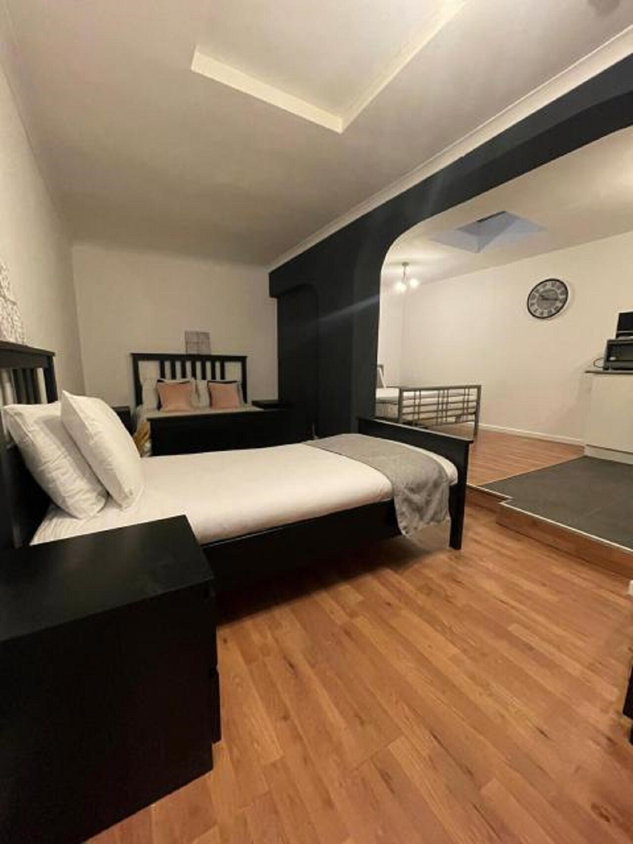 A bedroom with a bed, nightstands, a desk, and a chair.