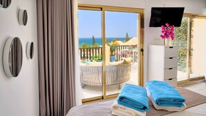 A hotel room with a bed, a TV, a view of the sea, and a balcony with outdoor furniture. - Sun-lovers paradise,  all day sun and views. (Marbella)