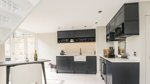 Eine moderne Küche mit dunklen Schränken, einer weißen Arbeitsplatte und einem eingebauten Backofen.