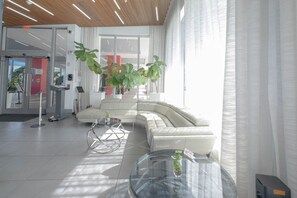 Relax in our spacious lobby with a comfortable sofa, glass tables, and a touch of greenery.
