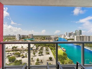 Enjoy breathtaking views of the coastal city from this high-rise's expansive balcony.