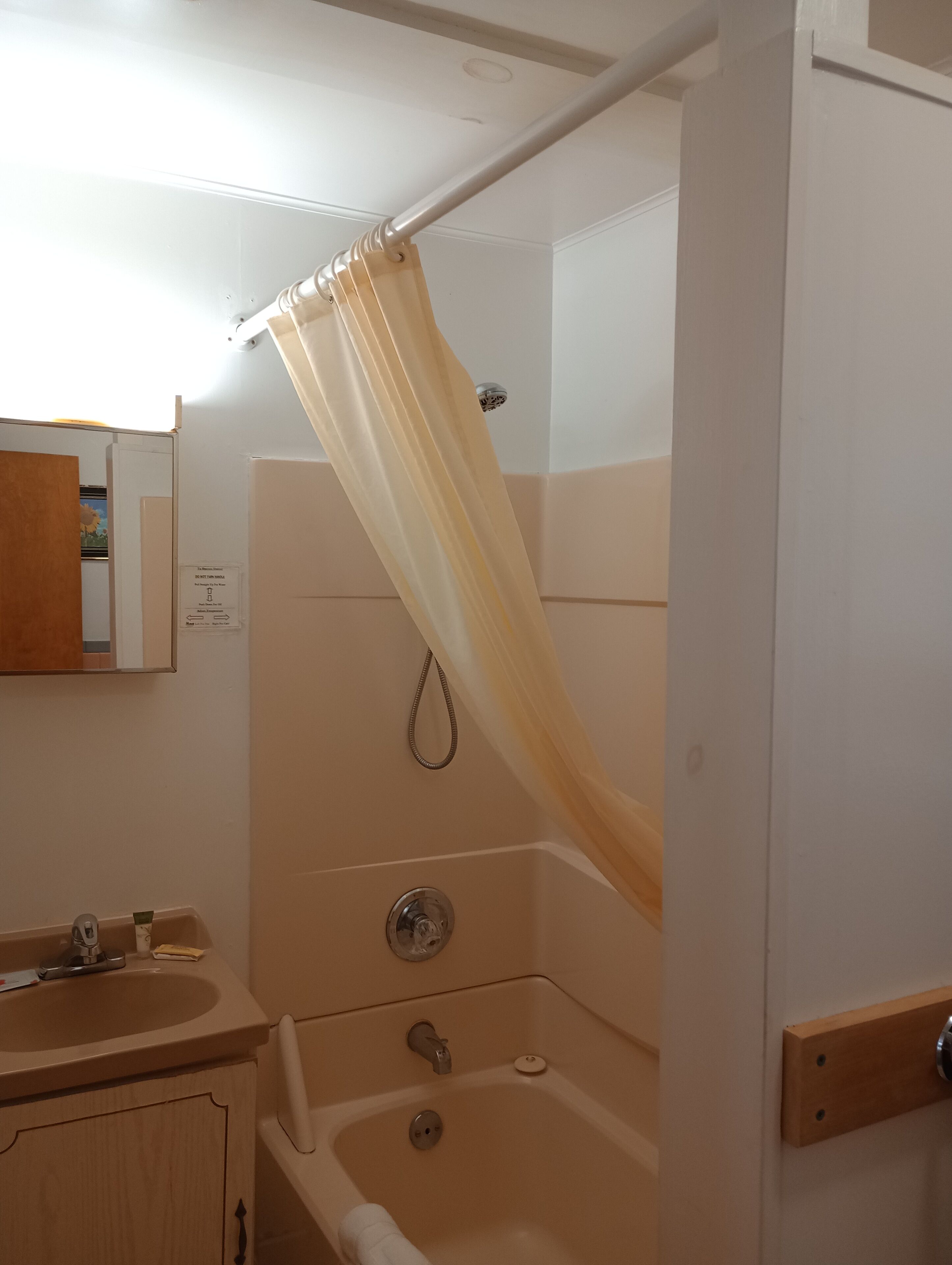 Un bagno con tenda da doccia, lavandino e vasca da bagno.
