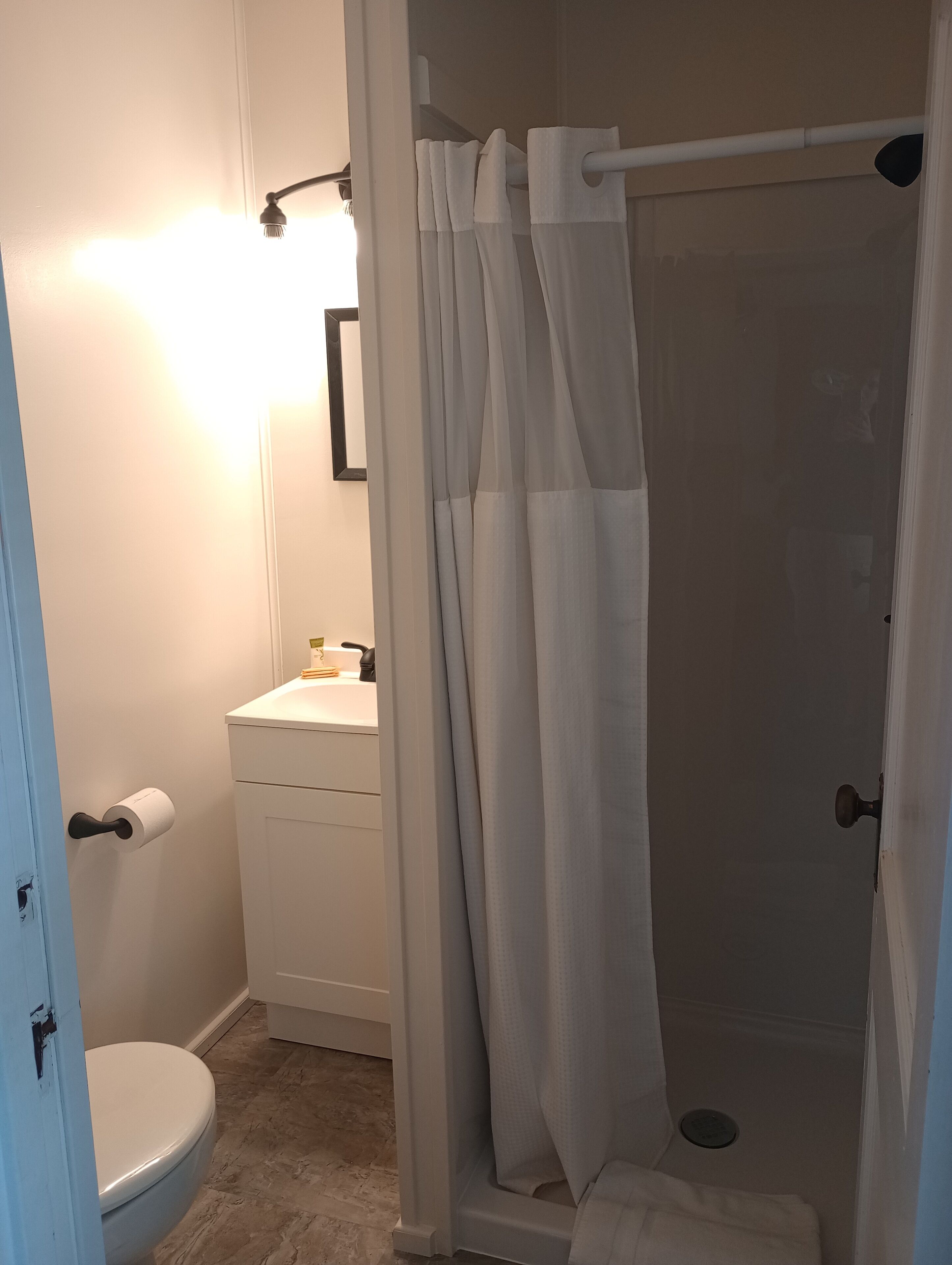 Een badkamer met toilet, wastafel en douche.